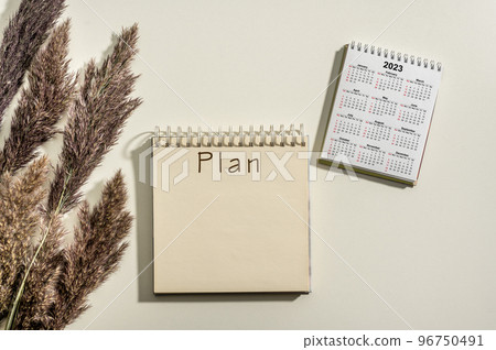2023 time for new start. Plan word and calendar 2023 on white table background. New Year plans for 2023, space for your text on notepad, calendar on desk. Business annual plan and development 96750491