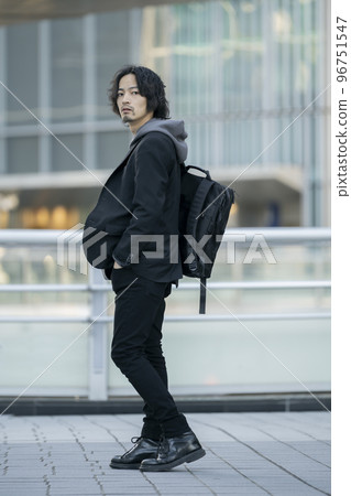A man in his early 30s with a backpack full body looking at the camera A man in his early 30s with a backpack full body looking at the camera 96751547