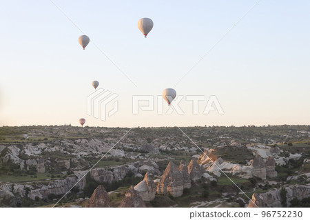 Hot air balloons fly in the evening sunset sky over Goreme National Park. 96752230