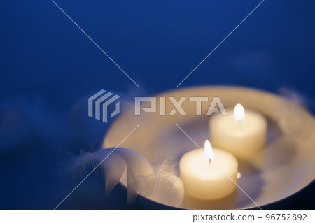 Candles and white feathers, the image of a holy night 96752892