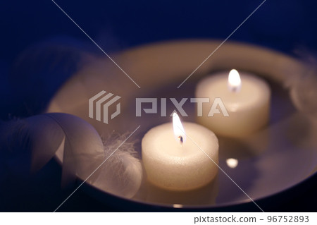 Candles and white feathers, the image of a holy night Candles and white feathers, the image of a holy night 96752893