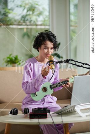 Teenage girl checking mike before streaming herself singing 96753549