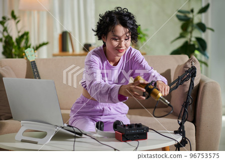 Teenage girl in lavender sweatpants and long sleeve setting mike to record voiceover Teenage girl in lavender sweatpants and long sleeve setting mike to record voiceover 96753575