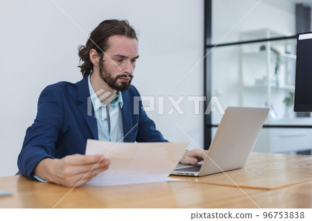 attractive businessperson sitting working in workplace. 96753838