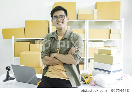 Young male online business owner working and looking at camera. 96754428