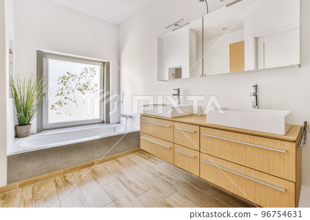 Flush toilet located between sink and shower in small tiled bathroom of contemporary apartment Flush toilet located between sink and shower in small tiled bathroom of contemporary apartment 96754631