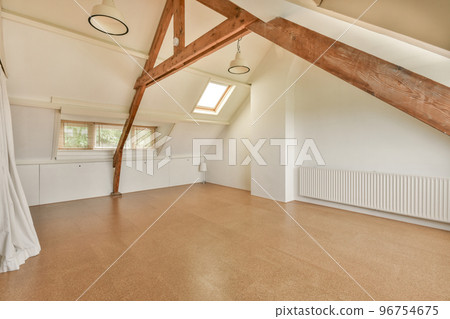 Open plan studio apartment with triangle shaped roof and construction of wooden beams in daylight Open plan studio apartment with triangle shaped roof and construction of wooden beams in daylight 96754675