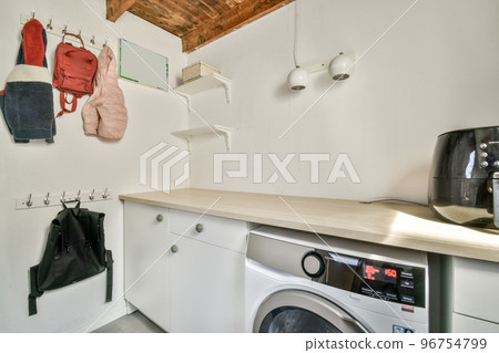 Modern cupboard , fridge and washing machine near doors in spacious room 96754799