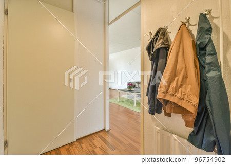 Square table placed on mat near couch and TV in stylish living room of contemporary apartment 96754902