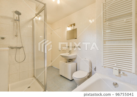 Modern home interior design of white bathroom with open bathtub and shower separated from toilet by partition wall 96755041