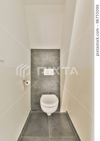 Interior of narrow restroom with wall hung toilet 96755098