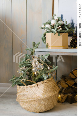 Fir or pine branches in a wicker basket at Christmas time. living room interior decor 96755382