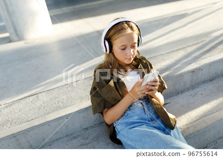 Photo of a positive cheerful teenage girl in park using mobile phone,top view Photo of a positive cheerful teenage girl in park using mobile phone,top view 96755614