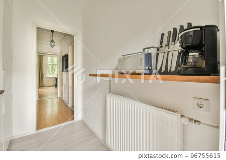 Well organized small home kitchen interior with sink under window and light furniture with stove and fridge in urban apartment 96755615