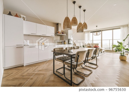 Table with chairs and flowers located near lounge area and kitchen in spacious room of contemporary apartment Table with chairs and flowers located near lounge area and kitchen in spacious room of contemporary apartment 96755630