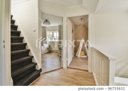 Corridor with white walls and doors leading to spacious room with windows and parquet floor in modern apartment Corridor with white walls and doors leading to spacious room with windows and parquet floor in modern apartment 96755631