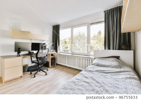 Comfortable chair placed near table with computer monitors against blank whiteboard and mirror in light home office in contemporary flat Comfortable chair placed near table with computer monitors against blank whiteboard and mirror in light home office in contemporary flat 96755633
