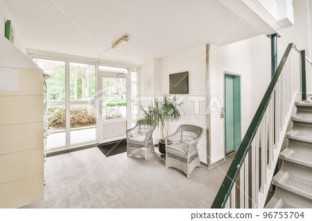 White hallway with wooden stairway leading to second floor of modern luxury apartment with minimalist interior design White hallway with wooden stairway leading to second floor of modern luxury apartment with minimalist interior design 96755704