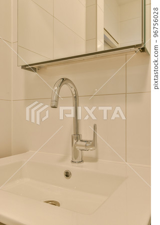 Flush toilet located between sink and shower in small tiled bathroom of contemporary apartment Flush toilet located between sink and shower in small tiled bathroom of contemporary apartment 96756028