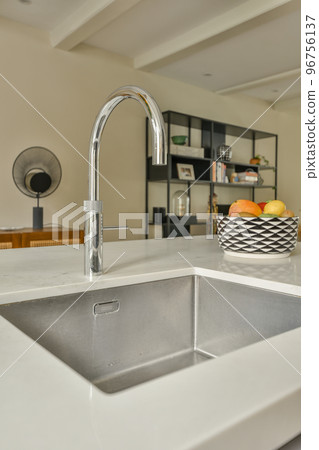 Contemporary minimalist style interior design of light studio apartment with wooden table and chairs in dining zone between open kitchen and living room with white walls and parquet floor Contemporary minimalist style interior design of light studio apartment with wooden table and chairs in dining zone between open kitchen and living room with white walls and parquet floor 96756137