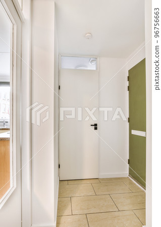 Interior of modern flat in minimal style with narrow empty corridor illuminated by lamps Interior of modern flat in minimal style with narrow empty corridor illuminated by lamps 96756663