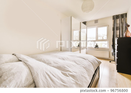 Comfortable bed located near glowing in contemporary bedroom with small window 96756800