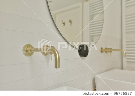 Flush toilet located between sink and shower in small tiled bathroom of contemporary apartment 96756857