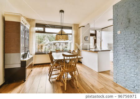 Home interior design of modern loft apartment with open kitchen in minimalist style and spacious dining zone with table and chairs Home interior design of modern loft apartment with open kitchen in minimalist style and spacious dining zone with table and chairs 96756971