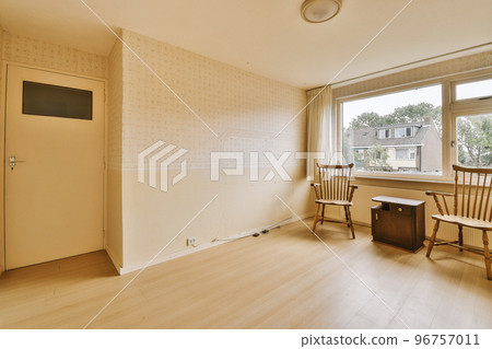 Modern cupboard and vintage chest placed near doors and wicker basket in spacious room with white walls and wooden floor Modern cupboard and vintage chest placed near doors and wicker basket in spacious room with white walls and wooden floor 96757011