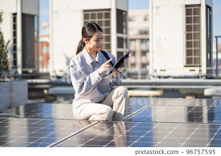 檢查太陽能電池板的年輕女工 檢查太陽能電池板的年輕女工 96757595