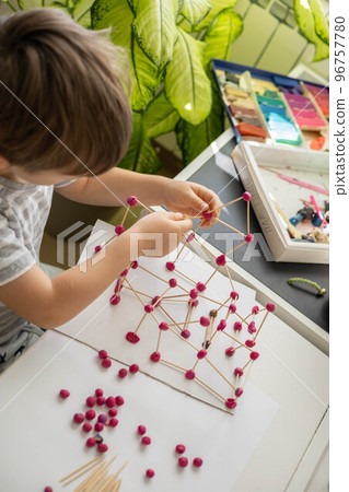 Confident cute baby boy playing and sculpt ball and toothpick design from plasticine fine motor skills early development 96757780