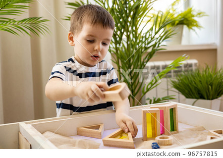 Cute baby boy playing sand table therapy toys developing game at home. Early development 96757815
