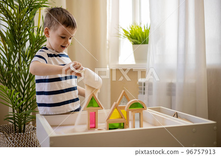 Cute baby boy playing sand table therapy toys developing game at home. Early development 96757913