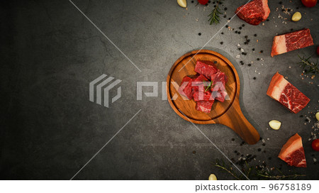 Raw picanha or rump beef meat chopped in cubes with pepper, sea salt and rosemary on black stone background Raw picanha or rump beef meat chopped in cubes with pepper, sea salt and rosemary on black stone background 96758189