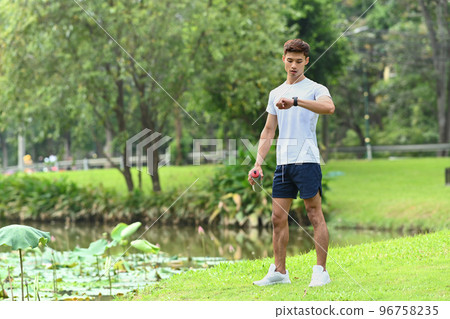 Full length of athletic man checking his heart rate data on smartwatch during morning workout Full length of athletic man checking his heart rate data on smartwatch during morning workout 96758235