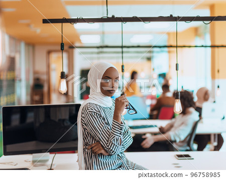 Protrait of a black ( african-american) female muslim standing in a modern business office while wearing a hijab. Protrait of a black ( african-american) female muslim standing in a modern business office while wearing a hijab. 96758985