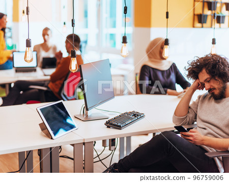 Group of multi-ethnic colleagues working on desktop computers, laptop and sharing their ideas in a modern office space.Young influencers work on online marketing projects. 96759006