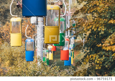 Colorful cableway cabins in autumn city park Colorful cableway cabins in autumn city park 96759173