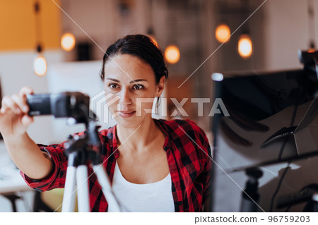 A young woman using a camera to present her business with online clients A young woman using a camera to present her business with online clients 96759203