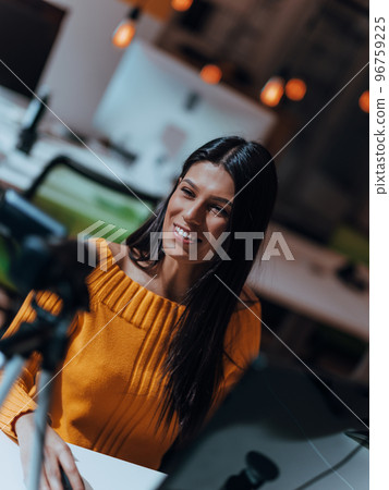 A young woman using a camera to present her business with online clients  96759225