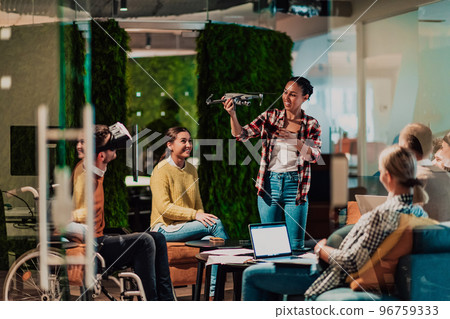Business persons with a disability at work in modern open space coworking office on team meeting using virtual reality goggles. Business persons with a disability at work in modern open space coworking office on team meeting using virtual reality goggles. 96759333