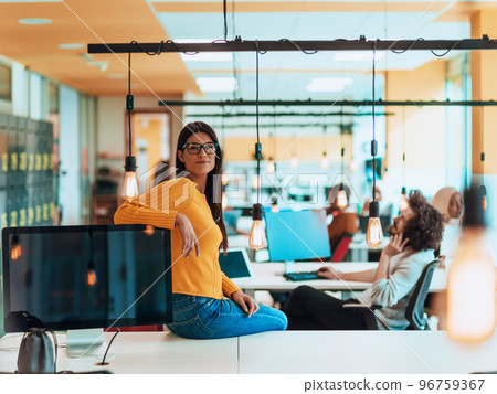 Female boss, manager executive posing in a modern startup office while being surrounded by her coworkers, team. Female boss, manager executive posing in a modern startup office while being surrounded by her coworkers, team. 96759367