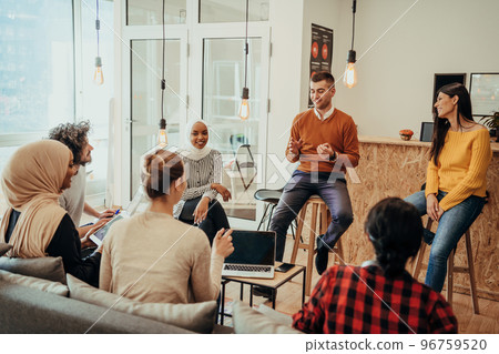 Young designer giving some new ideas about project to his partners in conference room. Business people discussing over new business project in office. 96759520