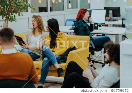 Group of multi-ethnic colleagues working on desktop computers, laptop and sharing their ideas in a modern office space.Young influencers work on online marketing projects. 96759672