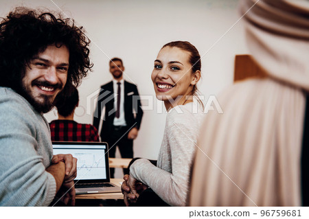 A group of diverse people listen to a lecture in business training while sitting in a modern classroom A group of diverse people listen to a lecture in business training while sitting in a modern classroom 96759681