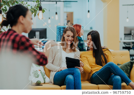 Group of multi-ethnic colleagues working on desktop computers, laptop and sharing their ideas in a modern office space.Young influencers work on online marketing projects. 96759750