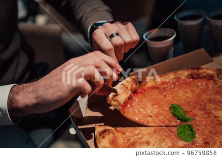Eating pizza with diverse colleagues in the office, happy multi-ethnic employees having fun together during lunch, enjoying good conversation, and emotions Eating pizza with diverse colleagues in the office, happy multi-ethnic employees having fun together during lunch, enjoying good conversation, and emotions 96759858