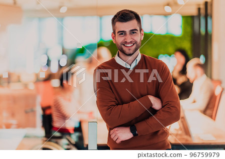 Handsome young business man standing confident in the office in front of his team 96759979