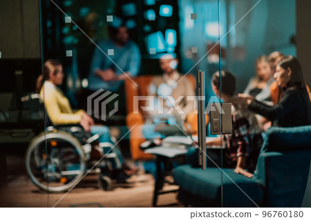 Businesswoman in wheelchair having business meeting with team at modern office. A group of young freelancers agree on new online business projects Businesswoman in wheelchair having business meeting with team at modern office. A group of young freelancers agree on new online business projects 96760180