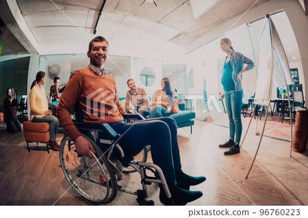 A pregnant businesswoman leads a creative meeting of a diverse business team in a modern coworking 96760223